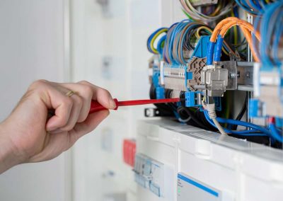 Handwerker Elektriker schraubt im Sicherungskasten.