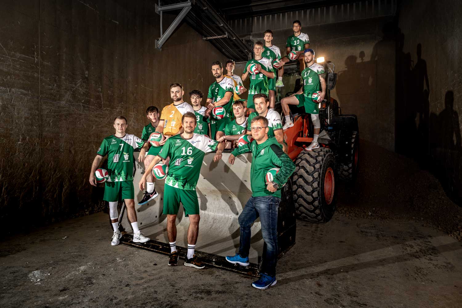 Die Herrenmannschaft der Westerwald Volleys auf einem Radlader platziert mit Industrieathmosphäre